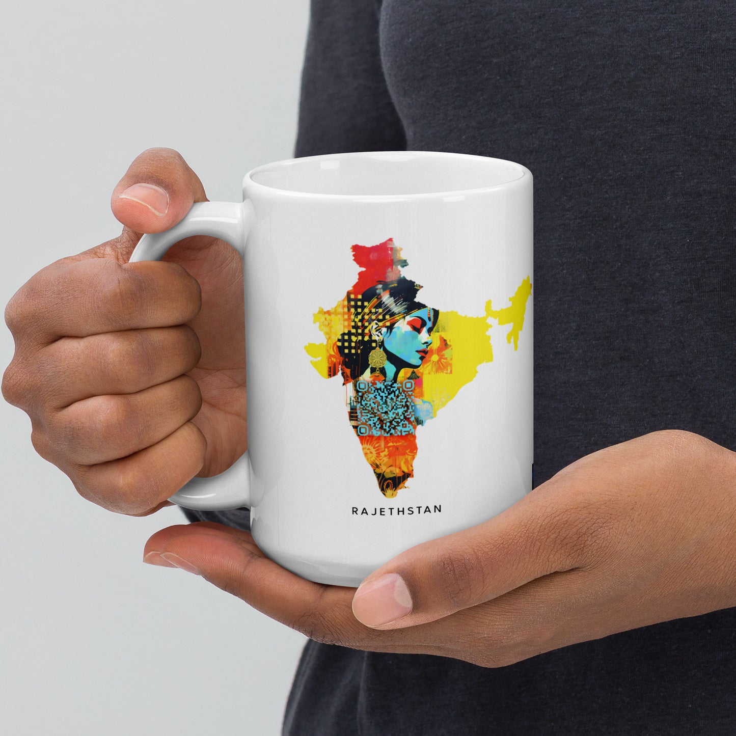 A 15 oz mug held by a woman, featuring a vibrant map of India in the style of fauvism and Bamileke art. The high-quality image captures robotic motifs and the artistic nuances of Prateep Kochabua, set against light gray and dark amber, embodying the fusion of fauvist figuratism and Afrofuturism