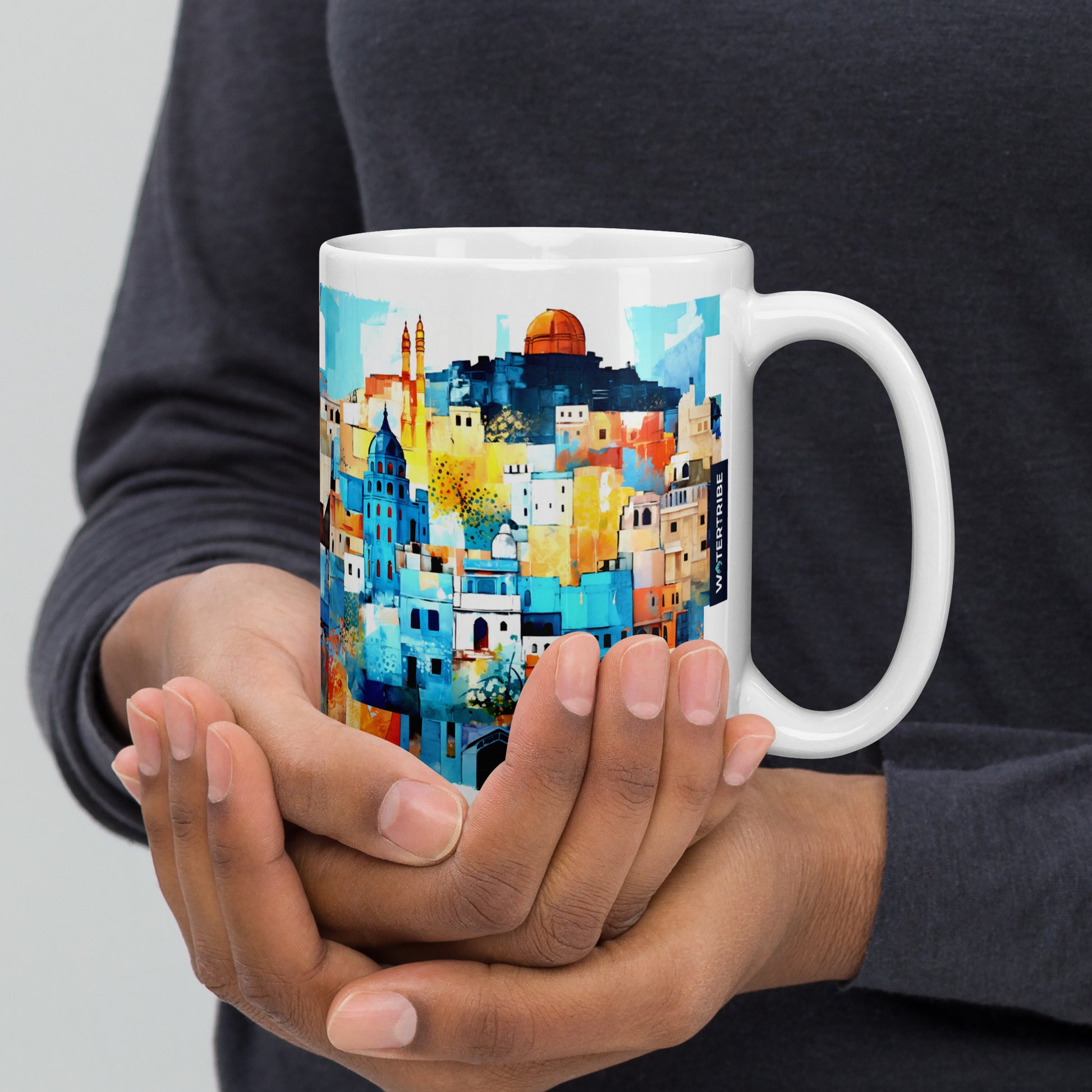 A white 15 oz mug adorned with a captivating painting of hillside houses, beautifully crafted in the style of light orange and azure, drawing inspiration from Rajasthan art. The composition, with its dark white and azure palette, exudes vibrancy and grace, bathed in golden light. This panorama-style design delivers a bold yet graceful aesthetic.